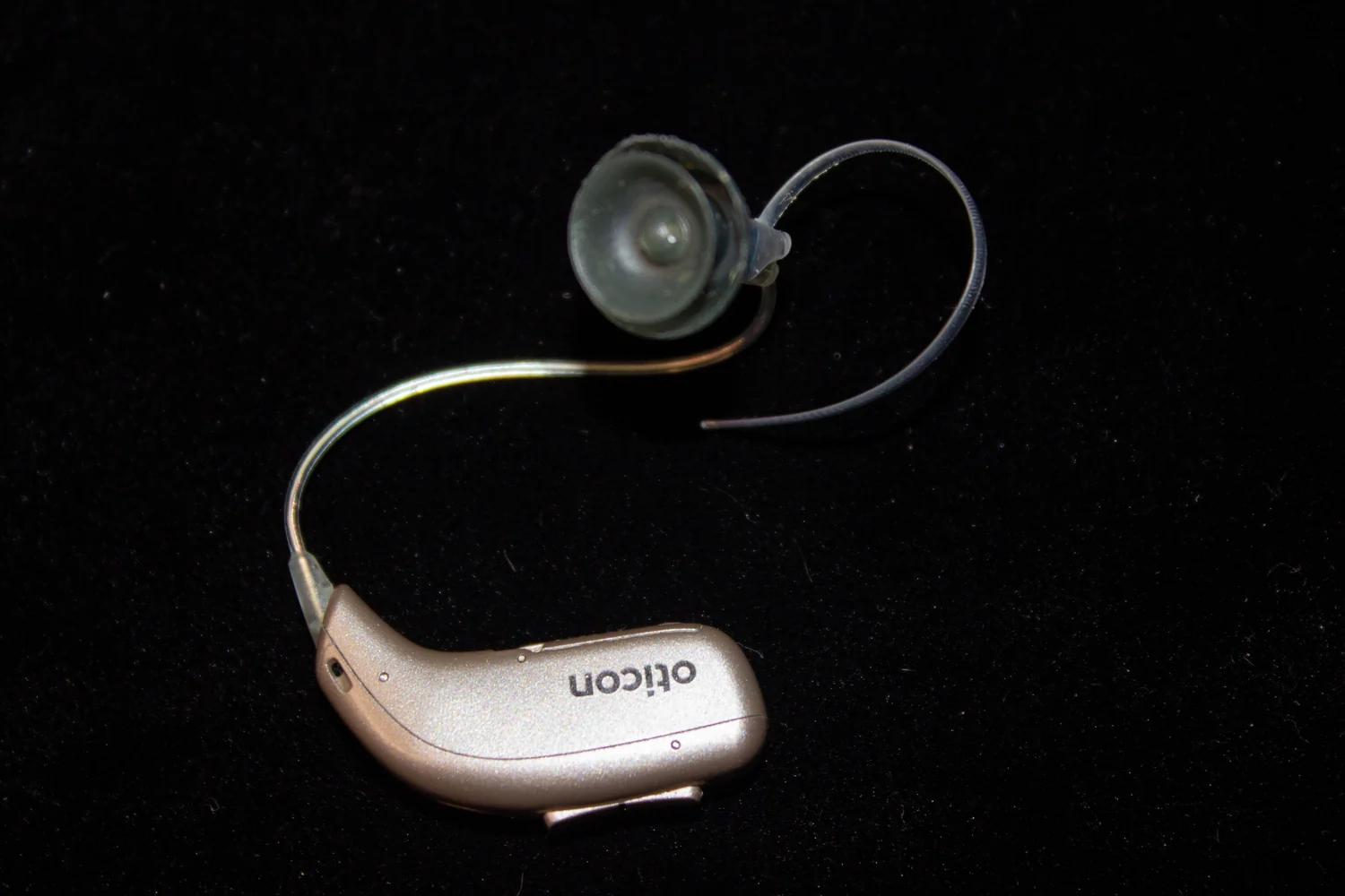 A behind-the-ear hearing aid photographed from above.
