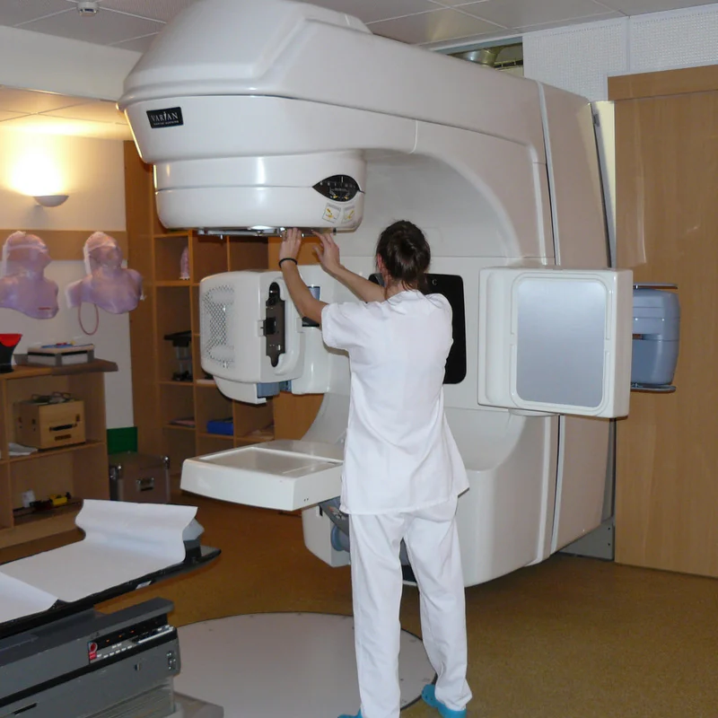 A radiotherapy treatment system with a rotating gantry and patient couch.