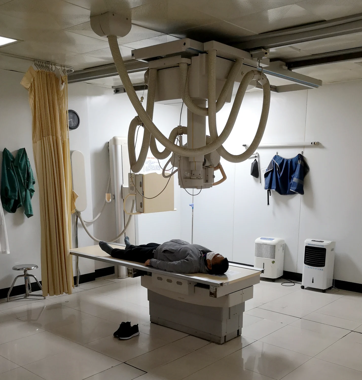 A hospital radiology room equipped for projection X-ray examinations.
