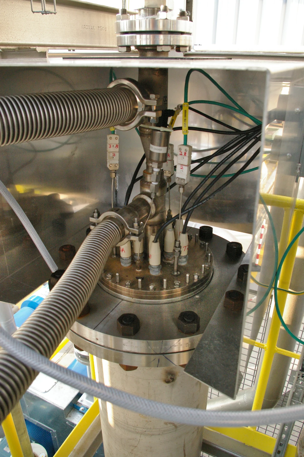 Steel pipes and an open reactor head in an industrial plasma installation.