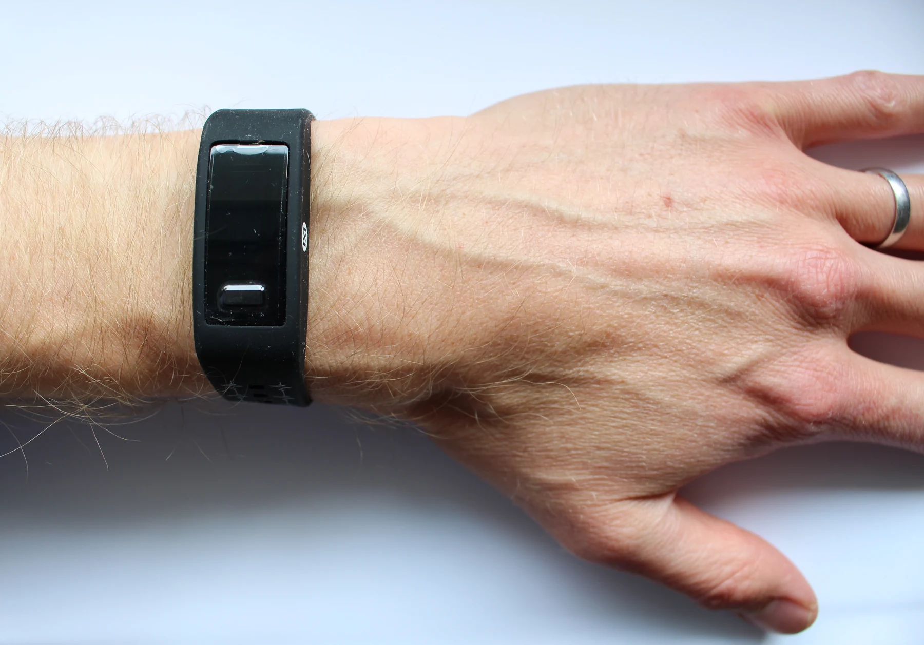 A slim black activity band is worn on a person's wrist.